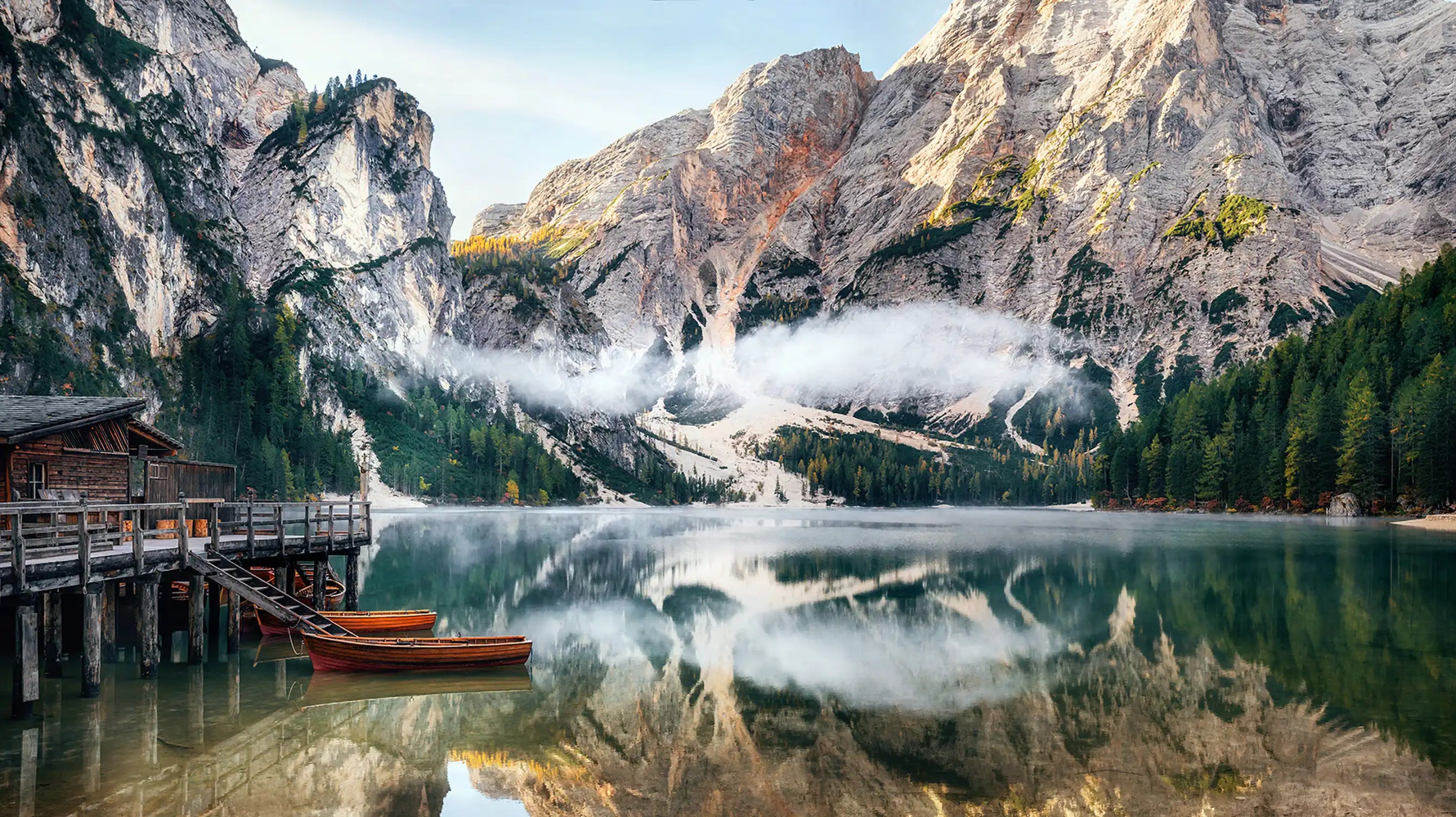 Panoramic view of Braies Lake with the hut and boats in Dolomites mountains and Seekofel in the morning, Sudtirol, Italy